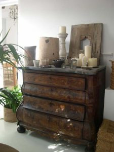 Cómoda antigua con marquetería decorada con velas y madera natural